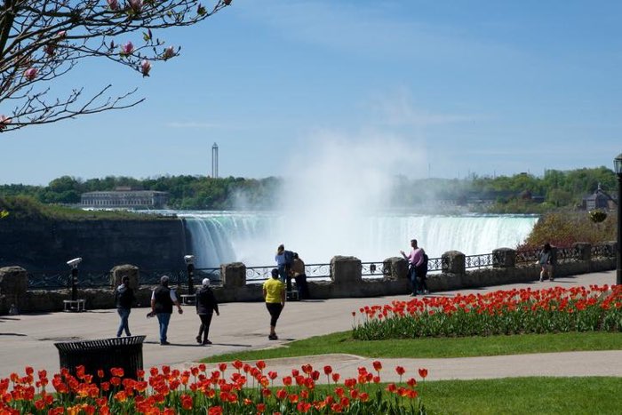 Visitors walking along the promenade beside Niagara Falls.